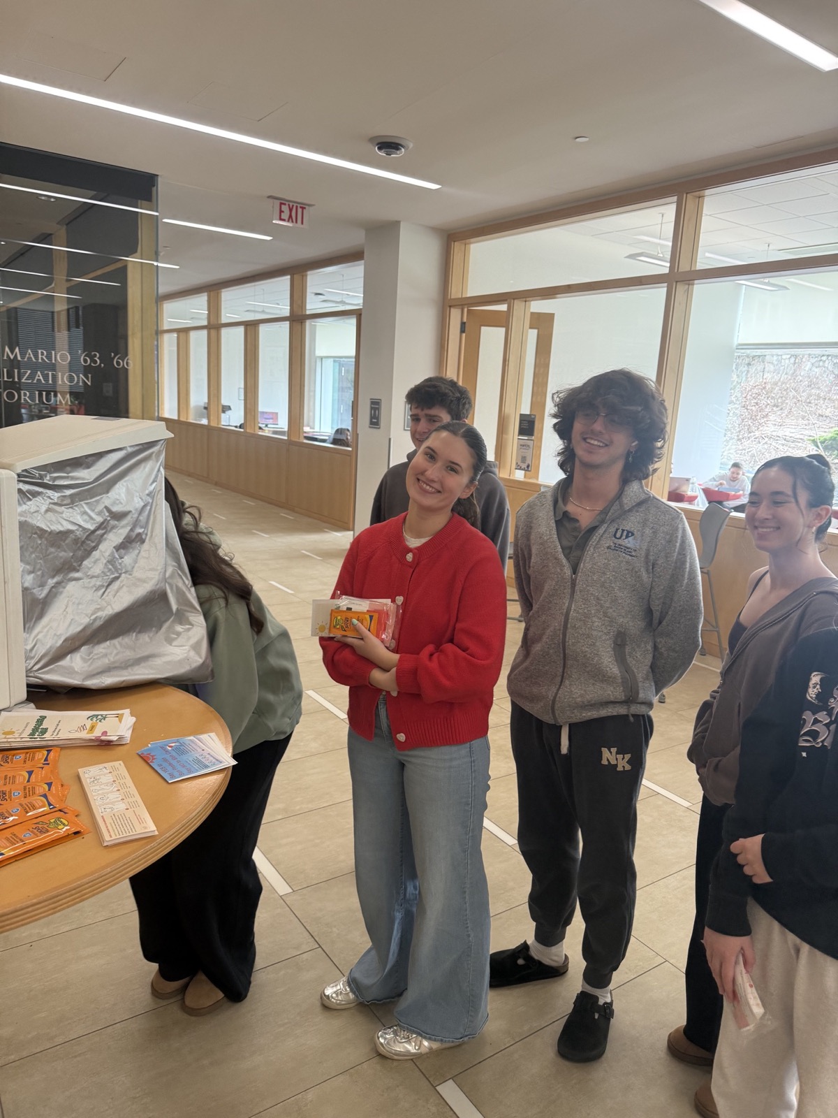 Students participating in a PhASEd campus event beside a skin-analysis station